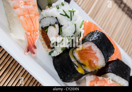 Gemischte Sushi-Rollen mit Bambus im Hintergrund Stockfoto