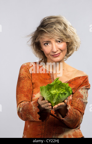 Schöne Frau mit Grünkohl, isoliert auf weiss Stockfoto