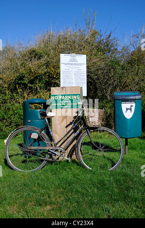 alten altmodischen Damen Fahrrad mit Korb, ruht neben einem No Parking und Erlass Schild am Snow Hill, West Wiitering, Sussex, UK Stockfoto