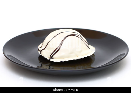 Kuchen auf einer schwarzen Platte isoliert auf weiss Stockfoto