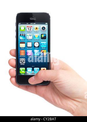 Nahaufnahme von einer Hand, die iPhone 5 mit blauen Desktop auf seinem Display isoliert auf weißem Hintergrund Stockfoto