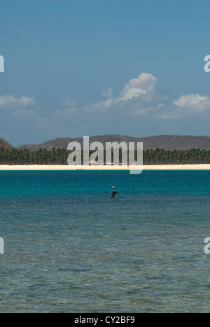 Ein einsamer Fischer genießt die ruhige Lage des Tanjung Aan auf Lombok, Indonesien Stockfoto