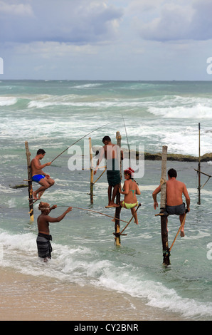 Touristen versuchen Stelzenläufer Fischen am Koggala in Sri Lanka. Stockfoto