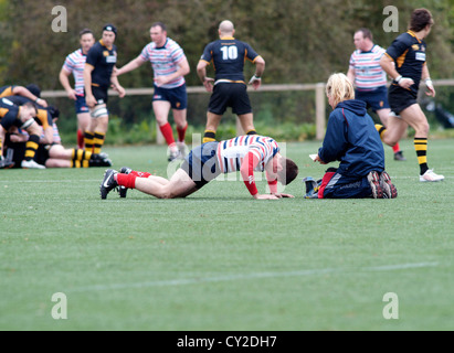 Physiotherapeuten kümmert sich um einen verletzten Spieler im Rugby-Match zwischen Burnage und Birkenhead park Stockfoto