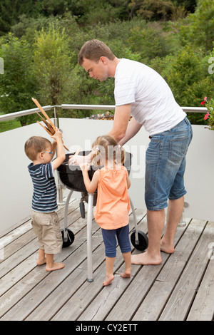 Familie beim Zünden des Feuers des Grills Stockfoto