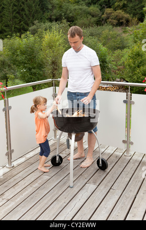 Familie beim Zünden des Feuers des Grills Stockfoto