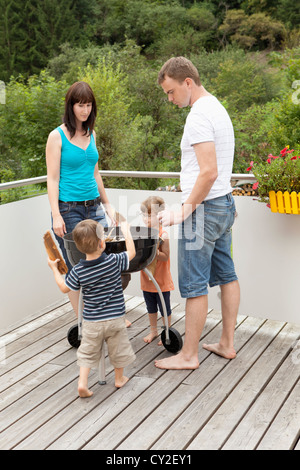 Familie beim Zünden des Feuers des Grills Stockfoto