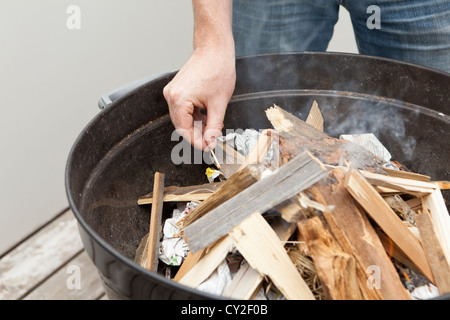 Grillmeister beim Zünden des Feuers des Grills Stockfoto