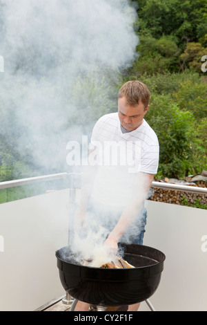 Grillmeister beim Zünden des Feuers des Grills Stockfoto