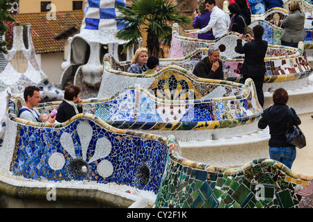 Menschen, die genießen Jugendstil Mosaik Fliesen Bänke, entworfen von Antonio Gaudi im Parc Güell in Barcelona, Spanien Stockfoto