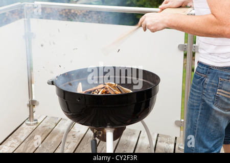 Grillmeister beim Zünden des Feuers des Grills Stockfoto