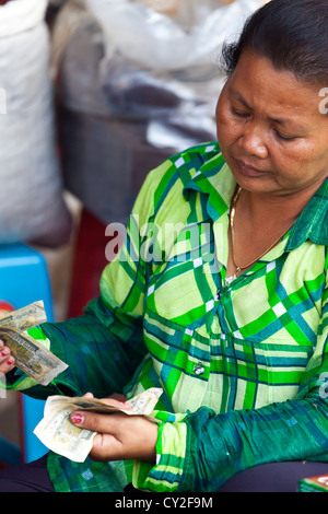 Marktfrau Geldzählen in Phnom Penh, Kambodscha Stockfoto