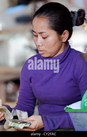 Marktfrau Geldzählen in Phnom Penh, Kambodscha Stockfoto