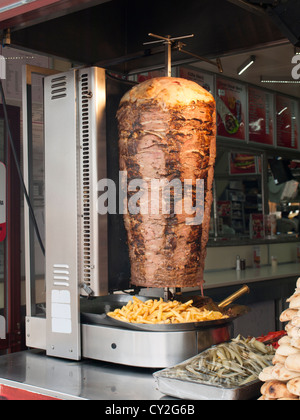 Lammfleisch auf dem rotierenden Grill, Döner und Pommes frites für hungrige Touristen vorbereiten Stockfoto