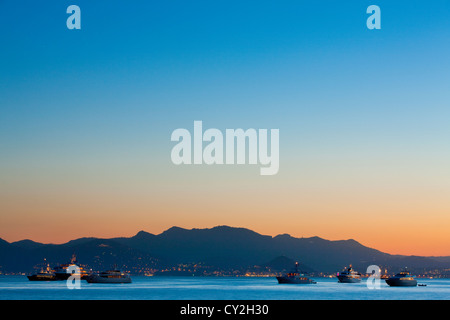 Luxuriöse Yachten in der Bucht von Cannes in der Abenddämmerung, Frankreich Stockfoto