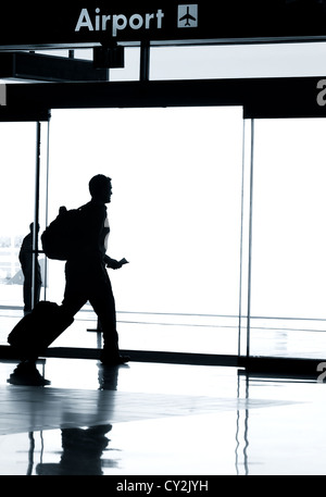 Geschäftsreisen Fotokonzept - Silhouette der Geschäftsmann im Flughafen mit Gepäck zu Fuß Stockfoto