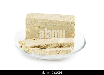 Sonnenblume Halva mit Erdnüssen auf eine Glas-Untertasse isoliert auf weißem Hintergrund. Östlichen Süßigkeiten. Stockfoto