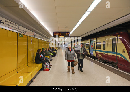 Passagiere und ein Zug auf der unteren Ebene der Glasgow Queen Street Bahnhof. Einige sind den Zug verlassen, einige sitzen Stockfoto