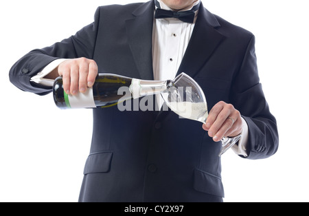 Mann im Smoking Gießen Champagner isoliert auf weiß Stockfoto