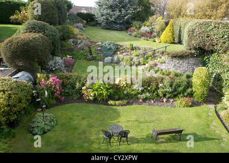 Ein angelegter Garten hinter dem Haus von einem Heim. Stockfoto