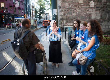 Mädchen aus der Touristeninformation hilft Touristen Stockfoto