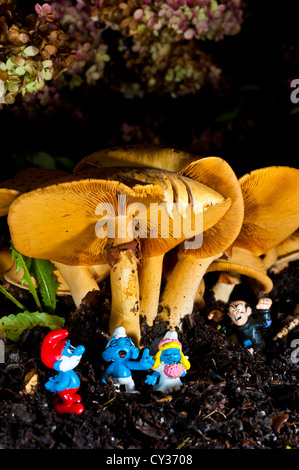 Schlümpfe gesammelt für eine Hochzeit unter einem Pilz mit Gargamel versteckt im Hintergrund Stockfoto