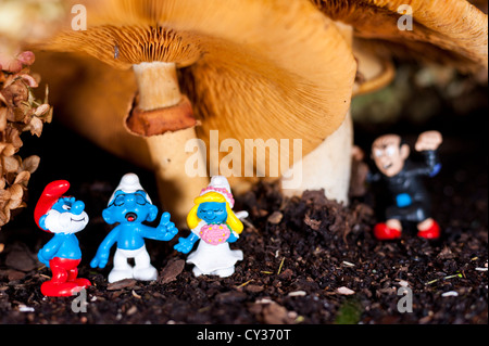 Schlümpfe gesammelt für eine Hochzeit unter einem Pilz mit Gargamel versteckt im Hintergrund Stockfoto