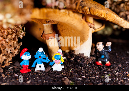 Schlümpfe gesammelt für eine Hochzeit unter einem Pilz mit Gargamel versteckt im Hintergrund Stockfoto