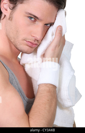 Mann sein Gesicht mit einem Handtuch abwischen Stockfoto