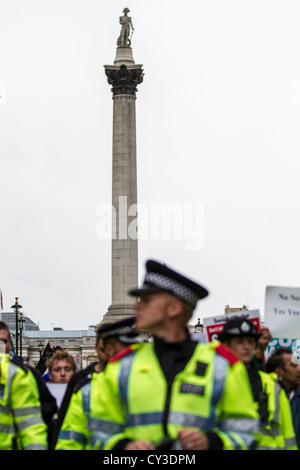 Stop The War, die Demonstranten marschieren umgeben von der Polizei nach Whitehall unter den wachsamen Augen von Nelson von seinem Posten Trafalgar Sq. Stockfoto