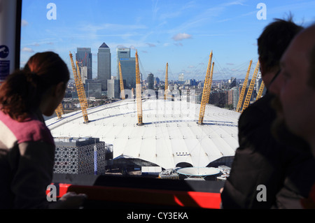 Blick auf die O2-Arena, mit Canary Wharf und die Docklands hinter, von der Emirates Air Line Seilbahn über den Fluss Themse Stockfoto