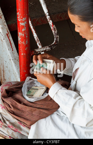 Frau Geldzählen in Rangun, Myanmar Stockfoto