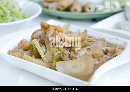 Geschmorte Schweinshaxe mit Gemüse- und Kräutergarten auf weißen Teller Stockfoto