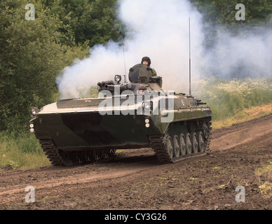 Eine finnische Armee BMP-2 Schützenpanzer Drehfreude der Motor mit einer Rauchfahne Auspuff. Stockfoto