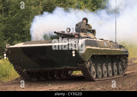 Eine finnische Armee BMP-2 Schützenpanzer Drehfreude der Motor mit einer Rauchfahne Auspuff. Stockfoto