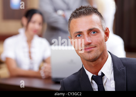 Gut aussehend executive Geschäftsmann mit seinem Team hinter Stockfoto