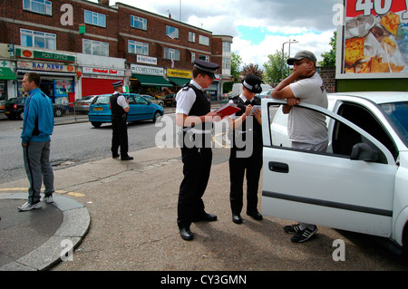 Eine Polizistin schreibt die Details von einem Autofahrer nach einem Stop und Suche eines Lieferwagens in Bounds Green, North London. Die Polizei g Stockfoto