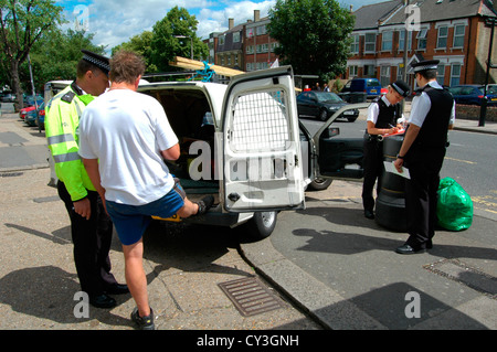 Polizisten überprüfen Sie van und die Details von einem Autofahrer nach einem Halt und Suche in Bounds Green, North London. Stockfoto