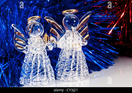 Zwei dekorative Glas Engel und Weihnachtsbaum Lametta auf weiß mit Reflexionen Stockfoto