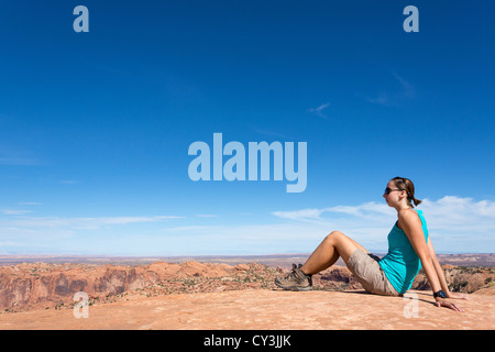 Junge Frau ruht auf einem Wal Felsen im Canyonlands National Park Stockfoto