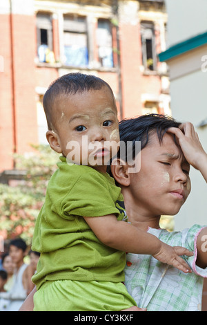 Kleiner Junge mit traditionellen Thanaka Creme auf seinem Gesicht in Rangun, Myanmar Stockfoto