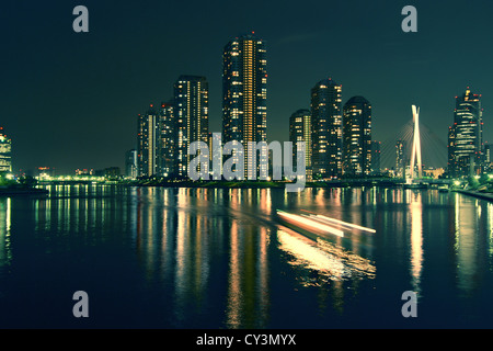 moderne Tokio Gebäuden mit Nacht-Spiegelbild im Wasser und leichte Spuren von beweglichen Schiff Japan Stockfoto