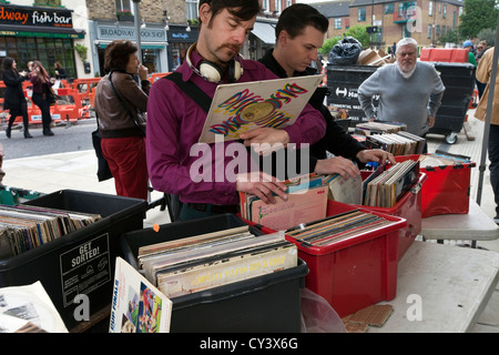 Ein Mann blättert durch gebrauchte Datensätze auf einem Marktstand in East London, Hackney, London Fields, Broadway Market Stockfoto