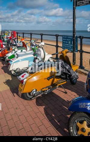 Eine Reihe von Mods Vespa Roller Mopeds promenade Vespas auf Cleethorpes direkt am Meer mit Strand im Hintergrund Stockfoto