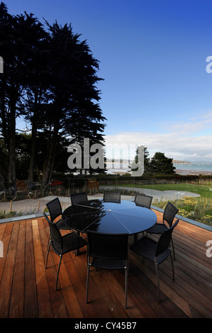 Ein schwarzer Granit Terrassentisch auf einem Holz geschmückt Terrasse in einem Luxus-Ferienhaus in der Nähe von Abersoch auf der Lleyn-Halbinsel im Norden Wale Stockfoto