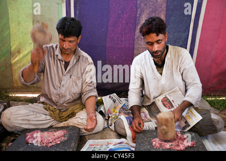 Wazas oder Köche in der Wazwan Tradition Pfund Lamm wie bereitet sie eine Gericht namens Ghustaba (Lamm Kugeln) in einem Wazwan fest. Stockfoto