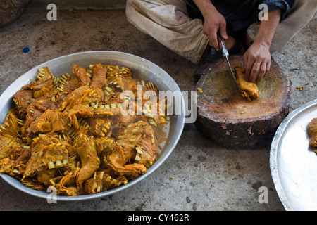 Ein Waza oder Koch in der kaschmirischen Tradition Koteletts Lamm Rippen für ein Gericht namens Tabakh Maaz auf eine Wazwan fest. Stockfoto