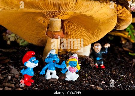 Schlümpfe gesammelt für eine Hochzeit unter einem Pilz mit Gargamel versteckt im Hintergrund Stockfoto