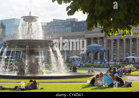 Schlossplatz Stuttgart, Schlossplatz - Menschen zu Fuß, liegen und sitzen auf dem Rasen im Park, entspannen im Sommer in der Stadt Stockfoto