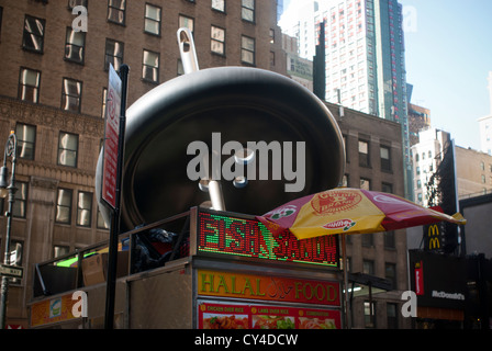 Eine Straße Warenkorb Verkauf von Halal-Lebensmitteln in der Nähe der "riesigen Nadel" Skulptur im Garment Center in New York Stockfoto